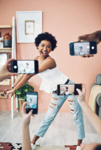 Shot of a beautiful young woman having her picture taken on multiple phones.